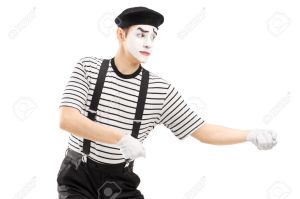 Male mime artist performing pulling virtual rope